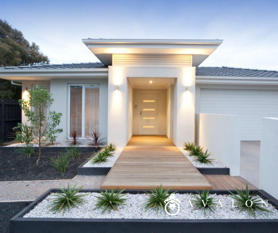 Also the white stucco house has a mid century modern front door with horizontal glass. And the shrub beds use white pebbles for mulch