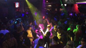 Also, Enigma Dance Bar prepares for Drag Show People are facing the stage in the picture with colorful dance lights.