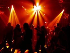 Furthermore, Orange disco lights fill the dance floor and all you can see are shadows of dancers having a blast.