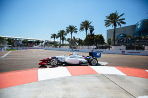 First, the track Turn by Dali Museum. Moreover the track has orange and white lines and palm trees in the background.
