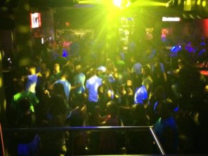 Also, Enigma Dance Bar prepares for Drag Show People are facing the stage in the picture with colorful dance lights.