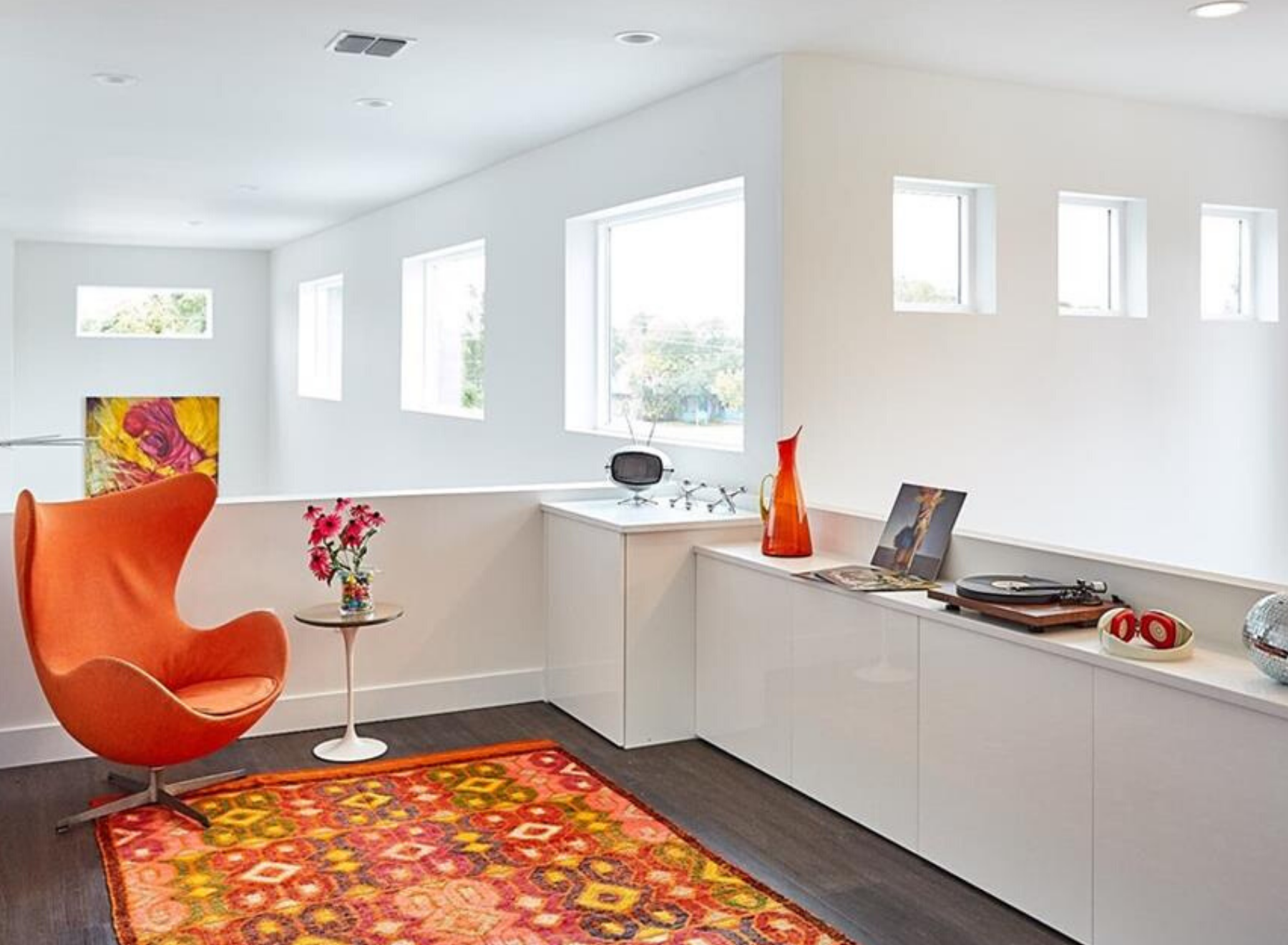 Moreover, Light fills the second floor of a home in Kenwood Neighborhood. Additionally, there is an orange chair on an orange rug in a white room.