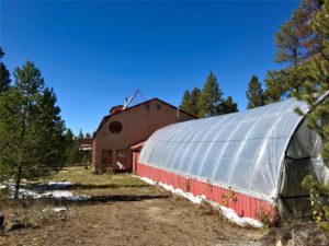 Exterior shot with greenhouse addition in the foreground and home in the background