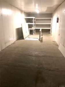 Bare room with some shelves and a trapdoor leading down