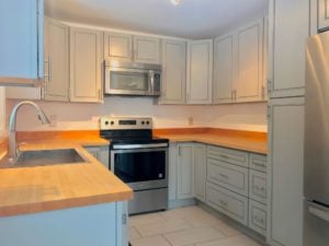 Kitchen with light gray Shaker-style cabinets, stainless steel appliances, and light brown countertops